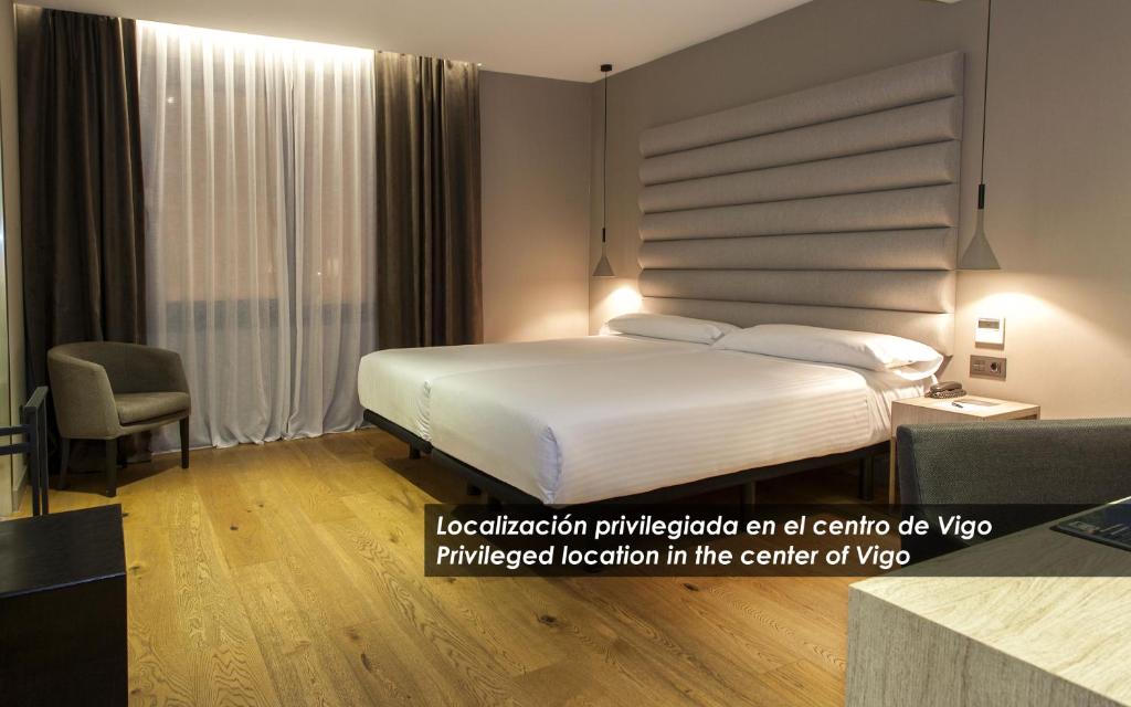 a hotel room with a bed and a chair at Zenit Vigo in Vigo