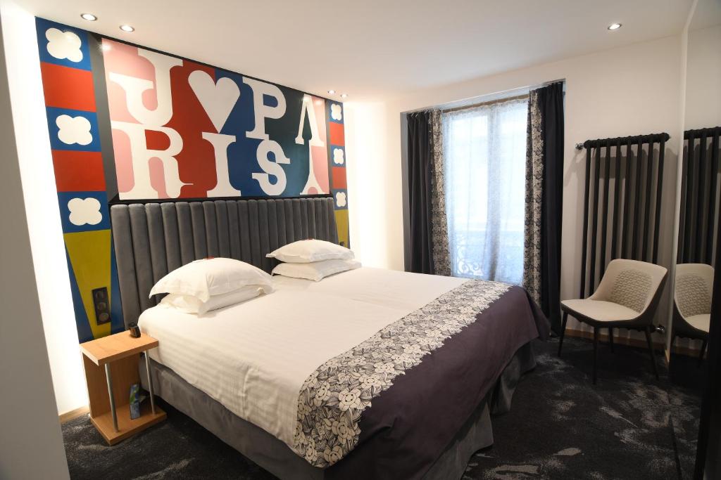 a bedroom with a bed with a large sign on the wall at Hotel Aida Opera in Paris