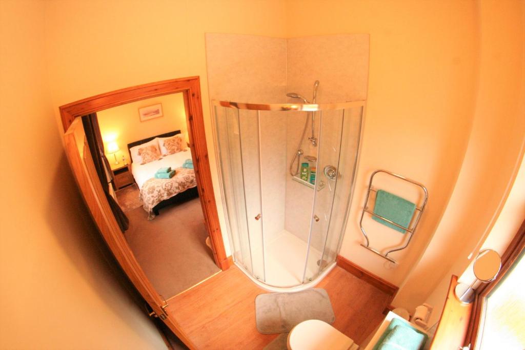a small bathroom with a shower and a bedroom at Talisker in Nairn