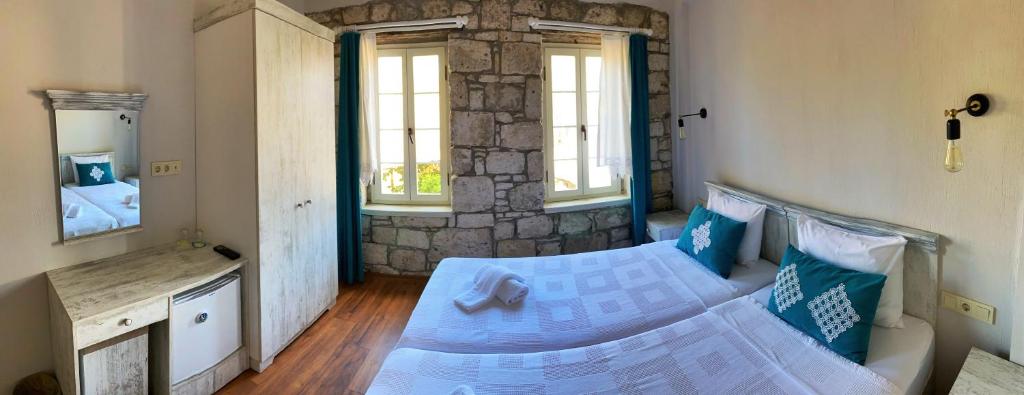 a bedroom with a bed and a stone wall at Oberj d'Azur Alaçatı in Alaçatı