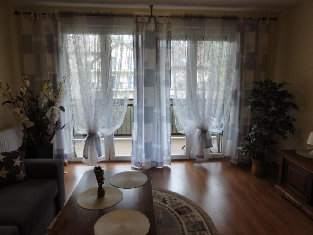 a living room with white curtains and a couch at Apartement Basti in Pobierowo