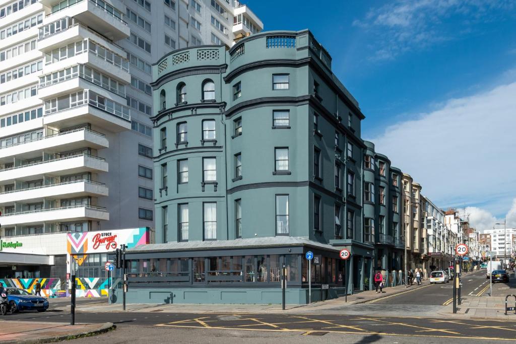 a tall green building on a city street at Selina Brighton in Brighton & Hove