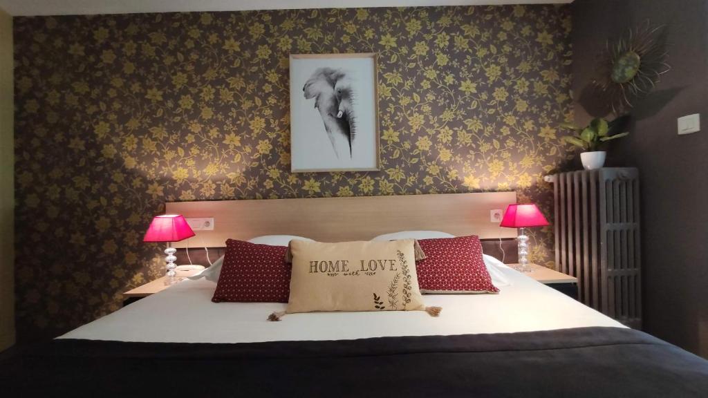 a bedroom with a large bed with two lamps at Celtic Hotel in Auray