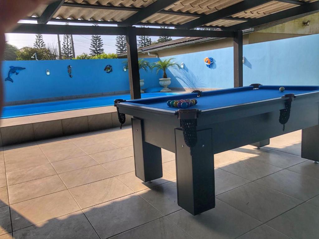 a pool table in a room with a swimming pool at Pousada Praia do Barco in Capão da Canoa