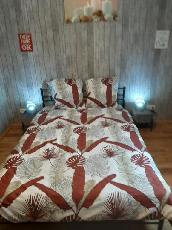 een bed met een rode en witte deken erop bij ESCALE DU BOURLINGUEUR in Charleroi