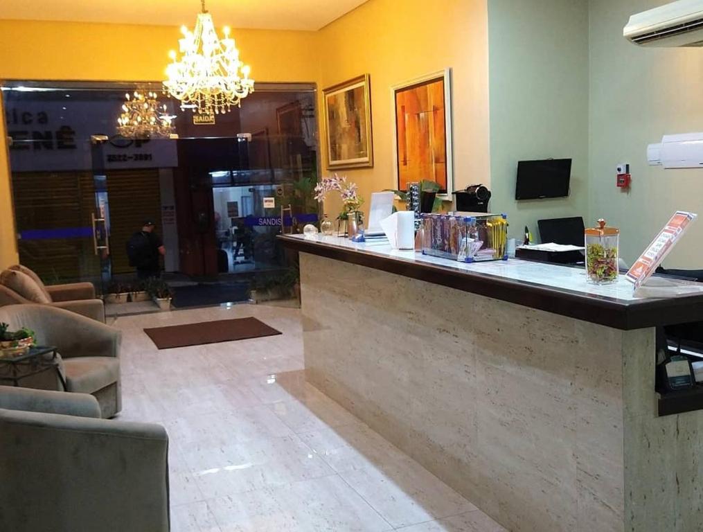 a lobby with a bar with a chandelier at Hotel Sandis in Santarém