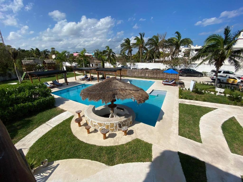 a patio with an umbrella and a swimming pool at HOTEL & BEACH CLUB OJO DE AGUA in Puerto Morelos