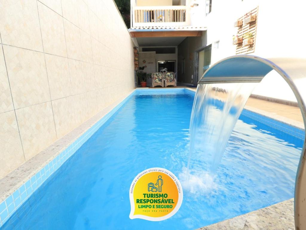 a swimming pool with a water fountain in a building at Pousada Recanto do Mucugê in Arraial d'Ajuda