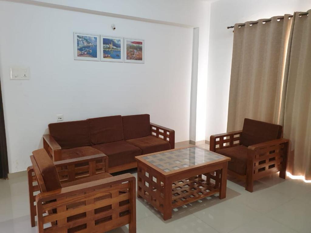 een woonkamer met een bank, 2 stoelen en een tafel bij MoonLight By Leela Homes in Arpora