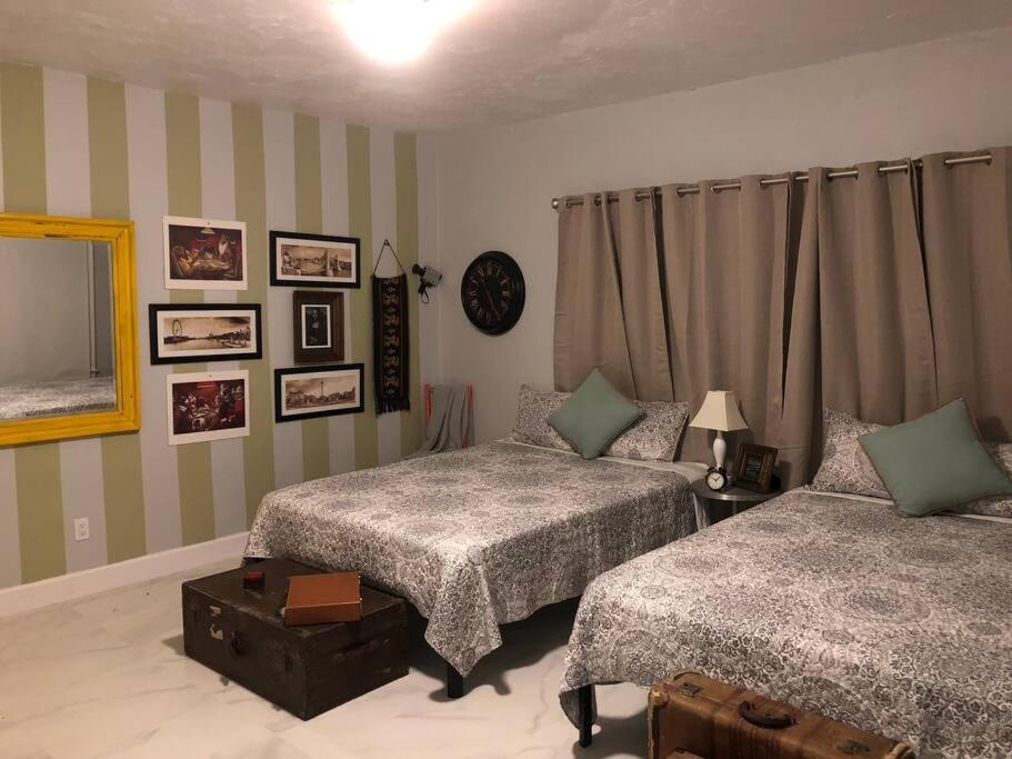 een slaapkamer met 2 bedden en een spiegel bij Spacious and Comfy Suite near MIA - 6G in Miami