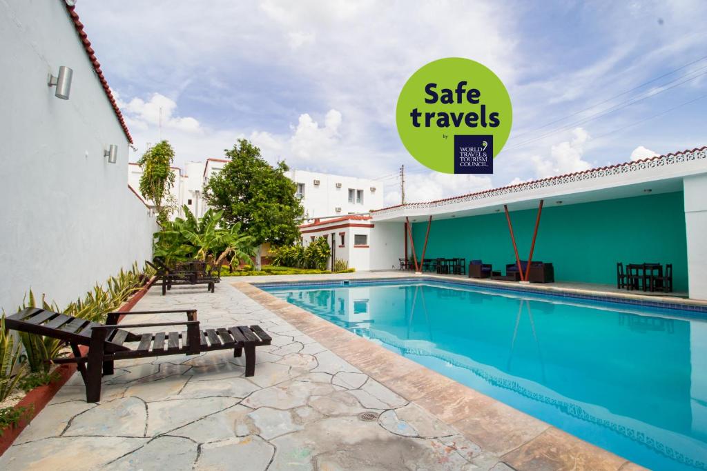 a pool at a hotel with a sign that says sale travels at Hotel Colon Merida in Mérida