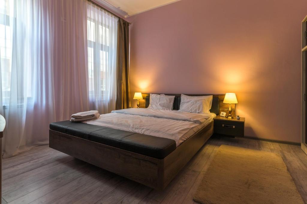 a bedroom with a large bed with two lamps at Apartment Queen in Sibiu