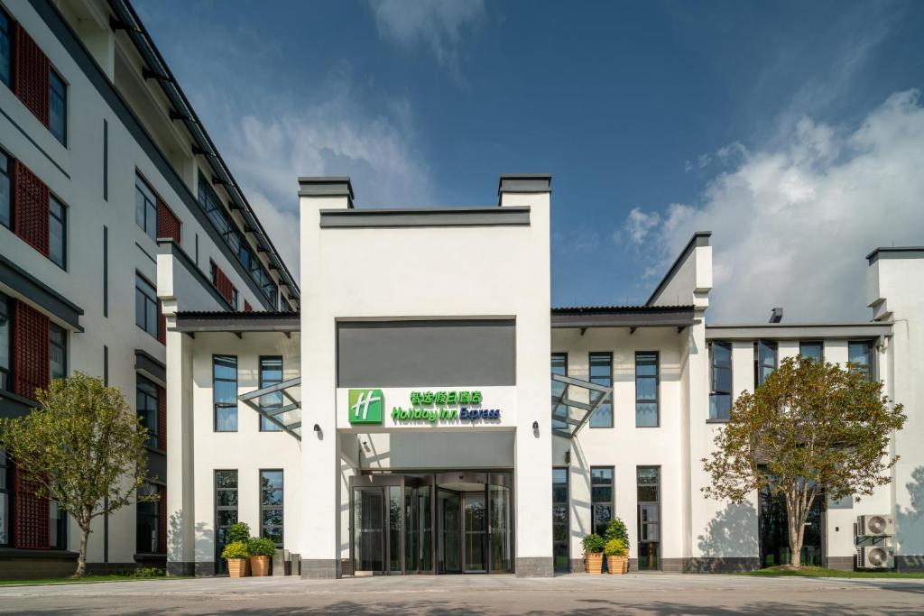 um edifício de escritórios com uma fachada branca em Holiday Inn Express Pinghu, an IHG Hotel em Pinghu