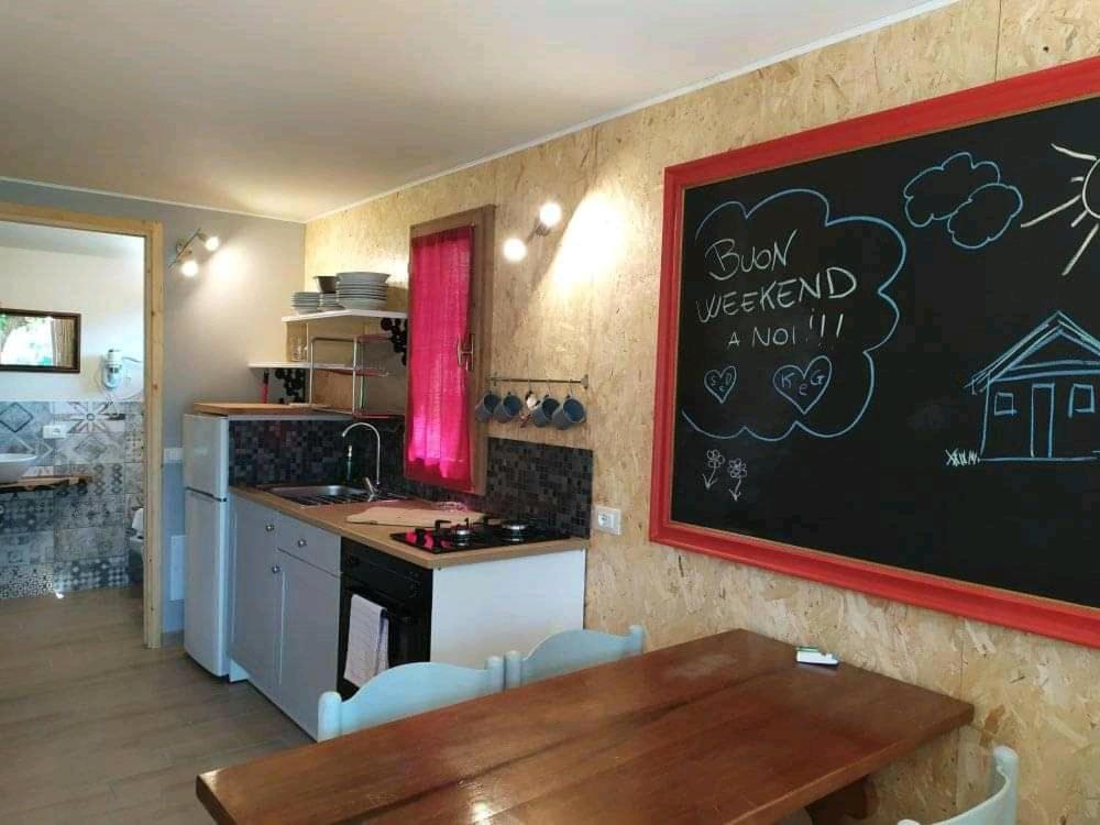 eine Küche mit einem Tisch und einer Tafel an der Wand in der Unterkunft bungalow classic in Zone