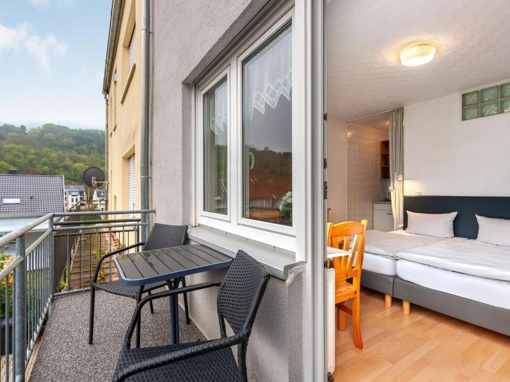 - un balcon avec un lit, une table et des chaises dans l'établissement Nice studio near Luxembourg, à Bollendorf