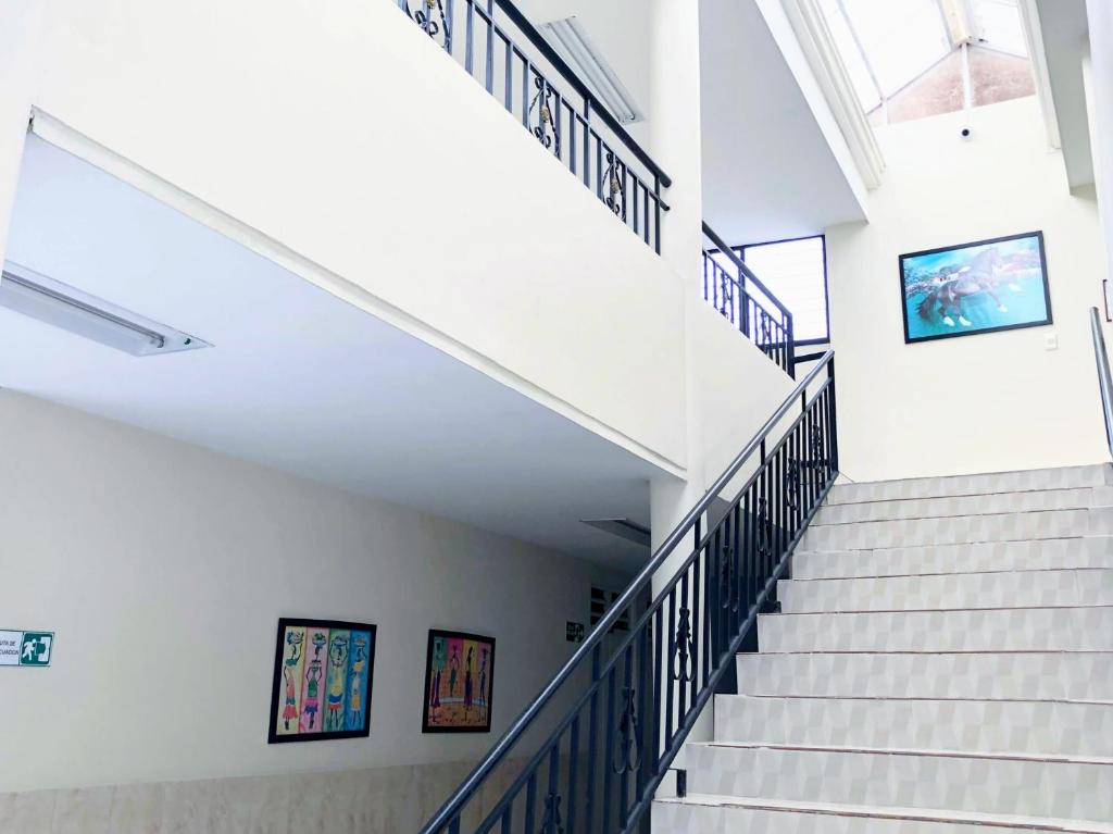 una scala in un edificio con pareti bianche e ringhiere blu di Hotel Morfeo a Tuluá