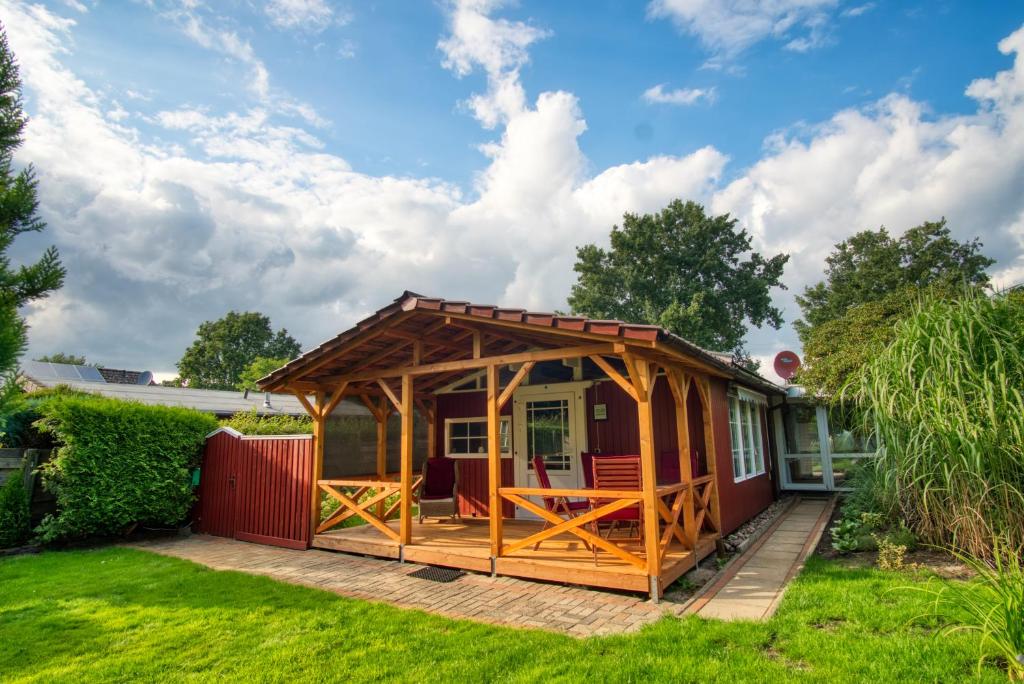 a small shed with a deck in a yard at HOMEFY - Schwanennest Am Haddorfer See in Wettringen