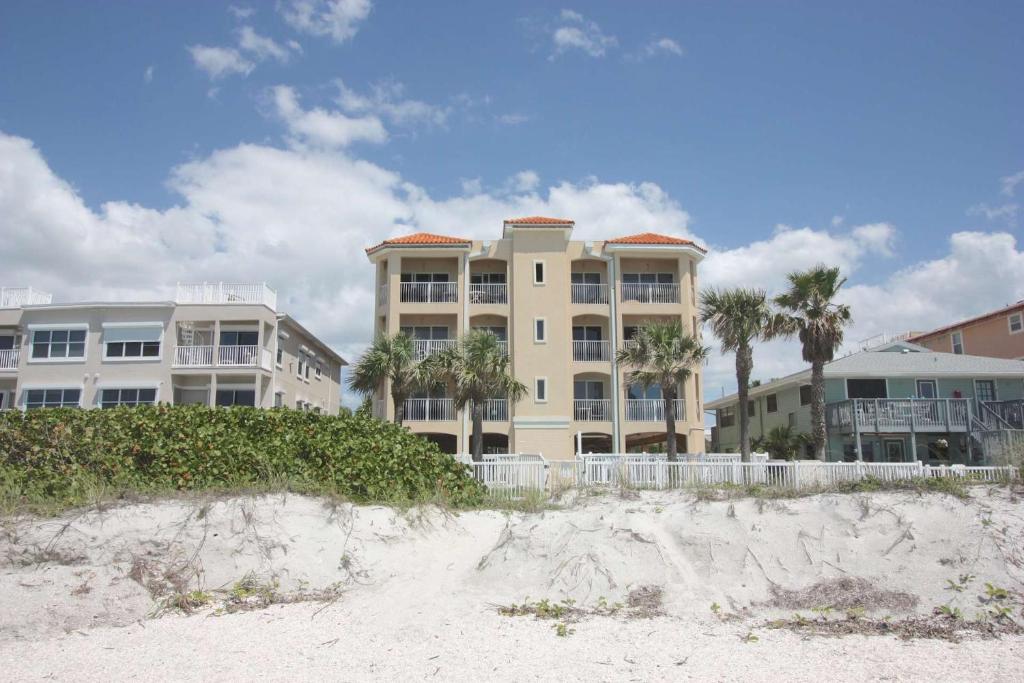 a building on the beach with palm trees in front of it at Sun & Sea C300 in Clearwater Beach