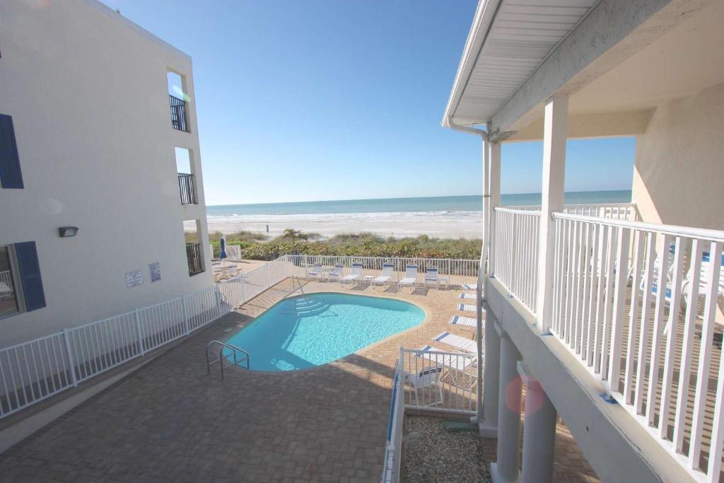 een balkon van een gebouw met een zwembad en het strand bij 201 Belleair Beach Club in Clearwater Beach