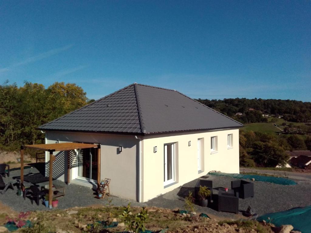 una piccola casa bianca con tetto nero di La Masquénada 85 m2, neuve, moderne, confort avec grand garage a Cublac