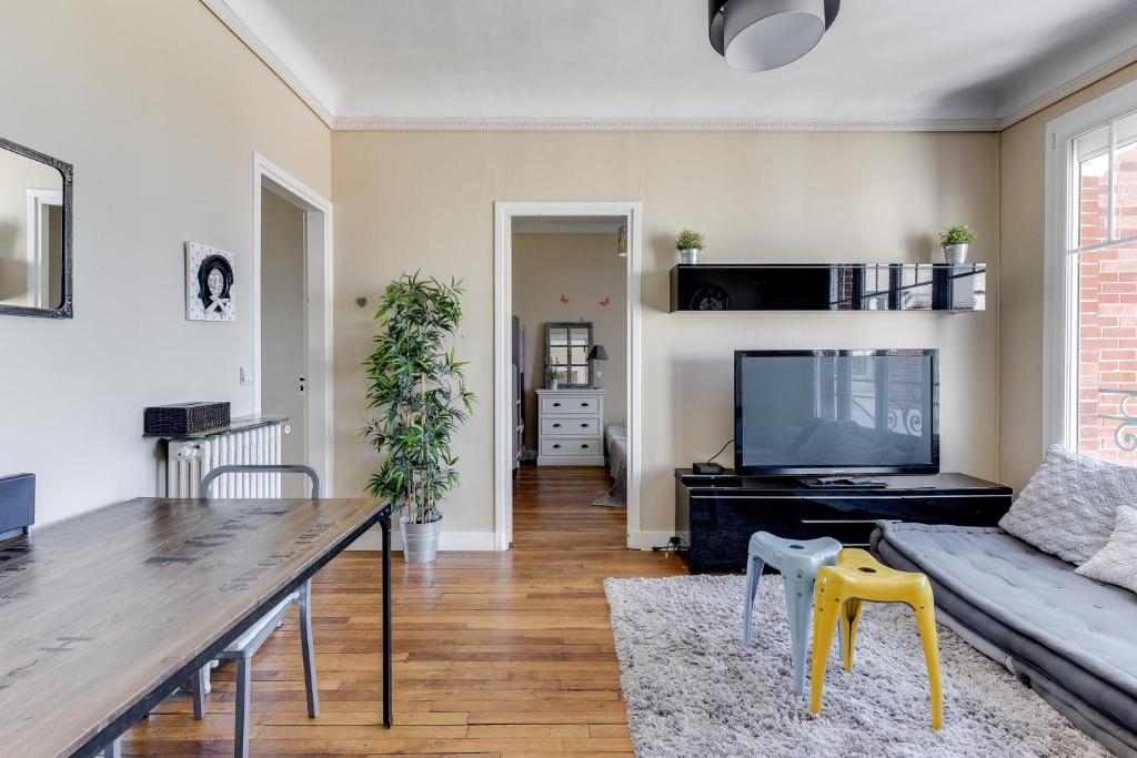 un salon avec une table et une télévision dans l'établissement Appartement moderne à Saint-Denis - 65 m² avec balcon, à Saint-Denis
