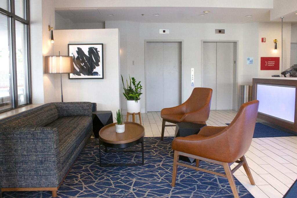 a living room with a couch and chairs at Holiday Inn Express & Suites Boston - Cambridge, an IHG Hotel in Cambridge