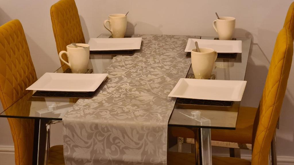 a table with four chairs and a table with glasses on it at Spacious 3 Bedroom House, 6 beds in Spondon, Derby with Parking in Derby
