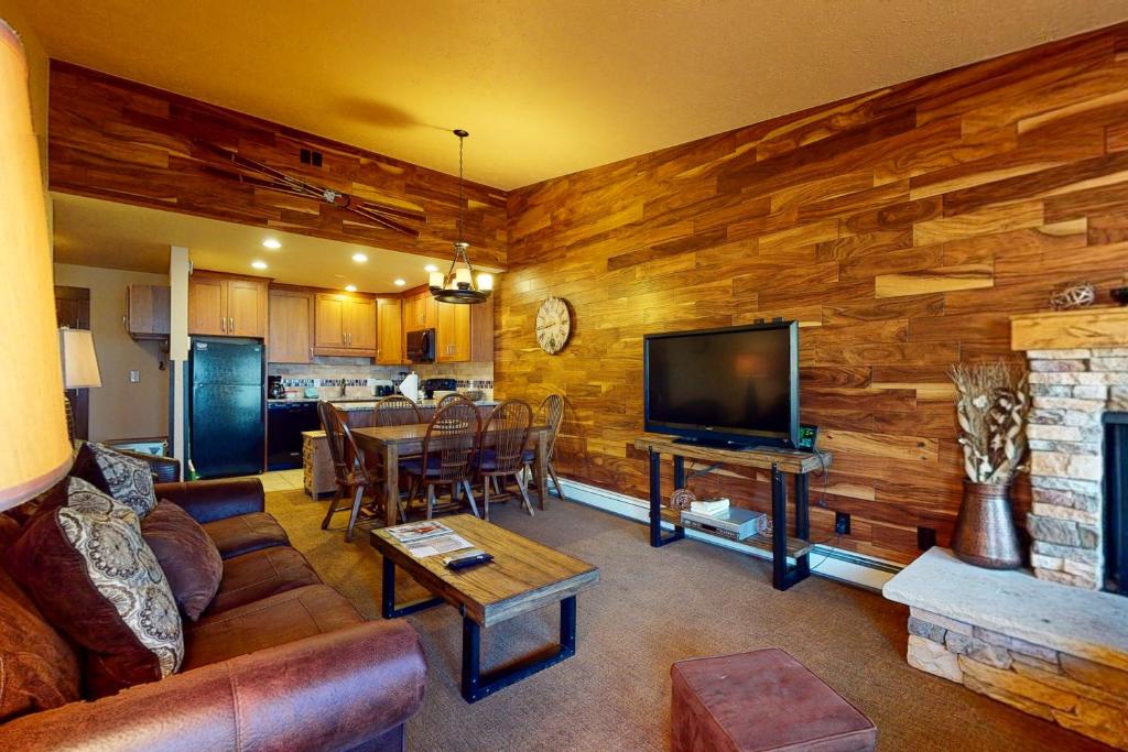 a living room with a couch and a tv and a kitchen at Copper Valley 114 in Copper Mountain