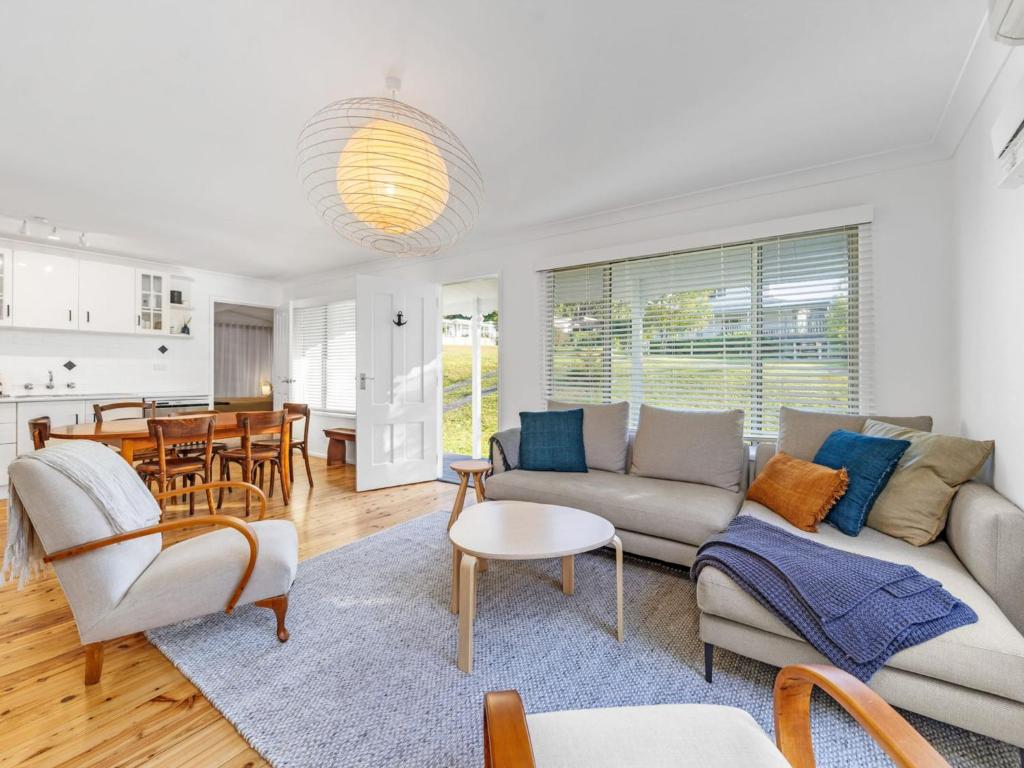 a living room with a couch and a table at Mobys at Hyams Beach in Hyams Beach