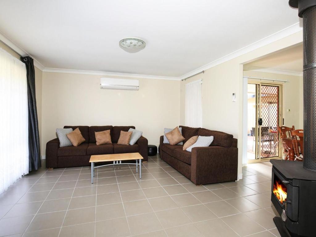 sala de estar con 2 sofás y chimenea en Kingfisher I Pet Friendly I 10 Min Walk to Beach en Sanctuary Point