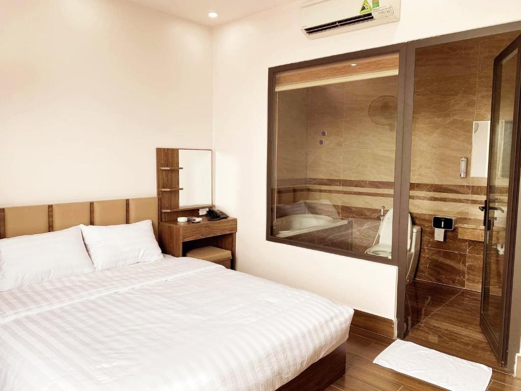 a bedroom with a bed and a glass shower at MV Hotel in Hai Phong