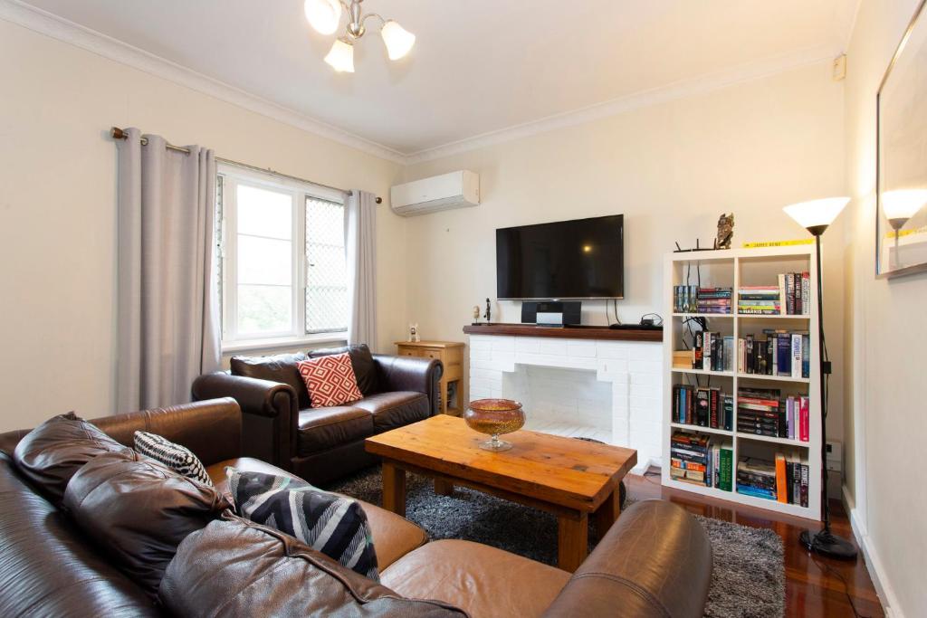 a living room with a couch and a fireplace at Cosy Cottage -3 Bedrooms Victoria Park in Perth