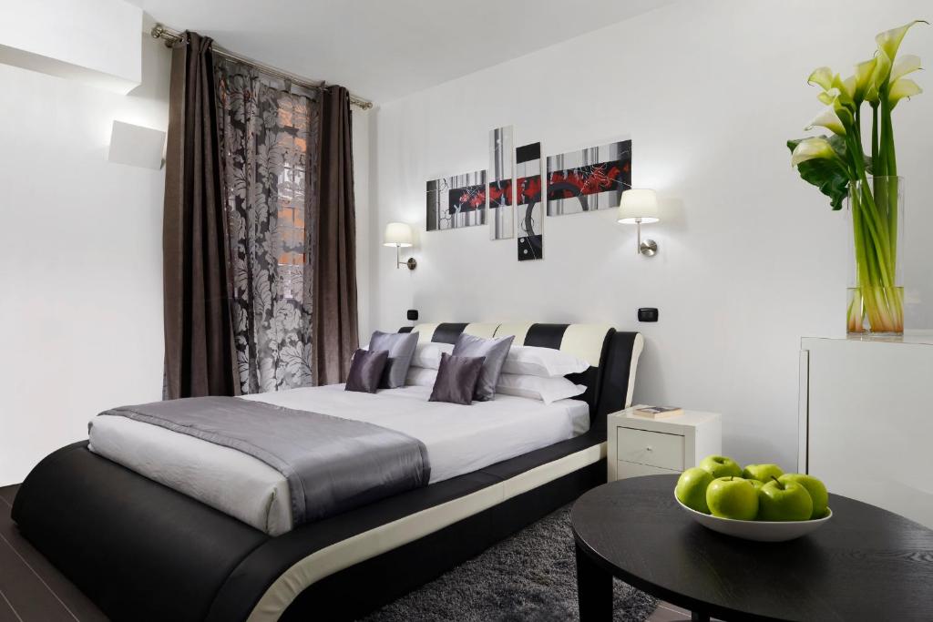 ローマにあるGregorio VII Luxury Suitesのベッドルーム1室(ベッド1台、リンゴの盛り合わせ付きテーブル付)