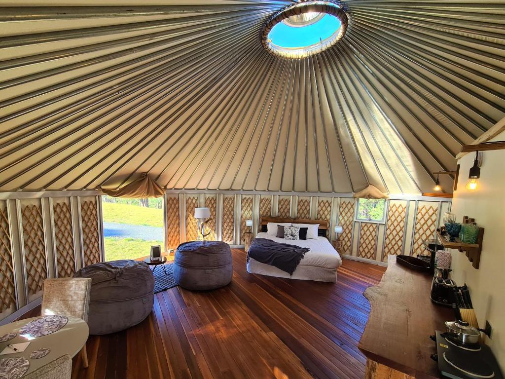 a bedroom in a yurt with a bed and furniture at Noosa Eco Retreat in Pomona