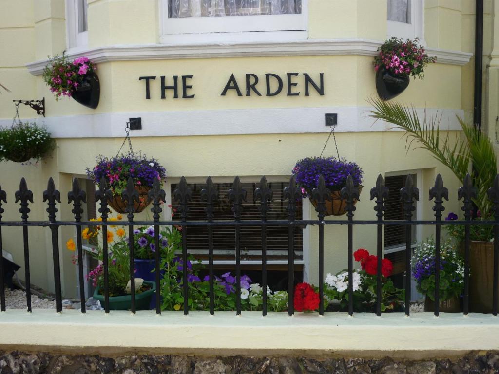 a sign for the garden on a building with flowers at Arden Guest House in Eastbourne