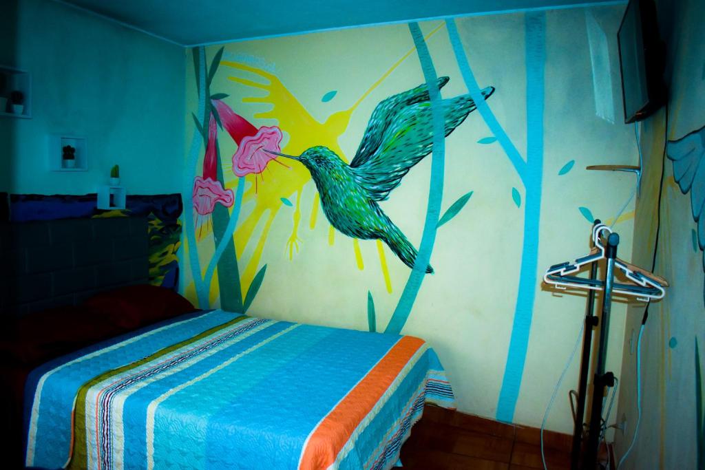 a bedroom with a painting of birds on the wall at Passion Hostel - Barranco in Lima