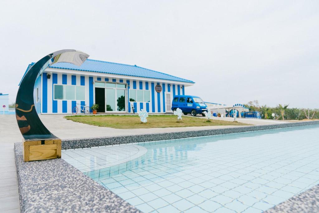 a swimming pool with a statue in front of a building at Loju Seaview Homestay in Xiaoliuqiu