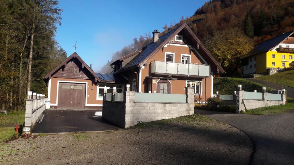 ein braunes Haus mit Garage auf einer Straße in der Unterkunft Ferienhaus Gerlach in Hintersee