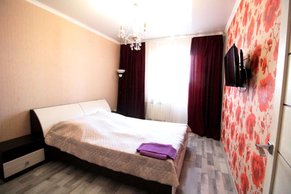 een kleine slaapkamer met een wit bed en een raam bij Апартаменты в центре OrenRoom56 in Orenburg