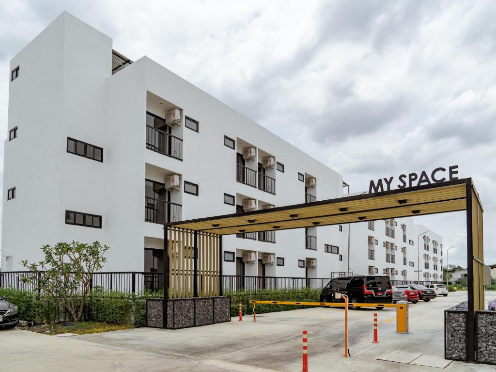 a large white apartment building with a large parking lot at My space69 in Ban Pak Khlong Khwang