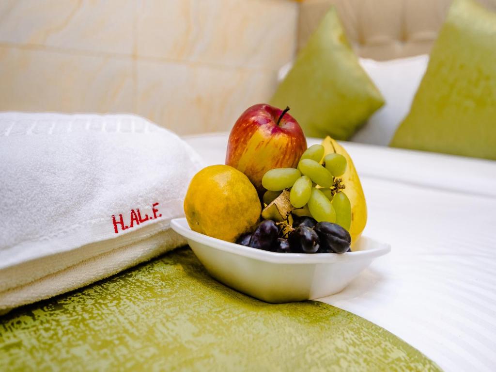 Hotel Al Fatah في مومباي: وعاء من الفواكه على طاولة بجوار منشفة