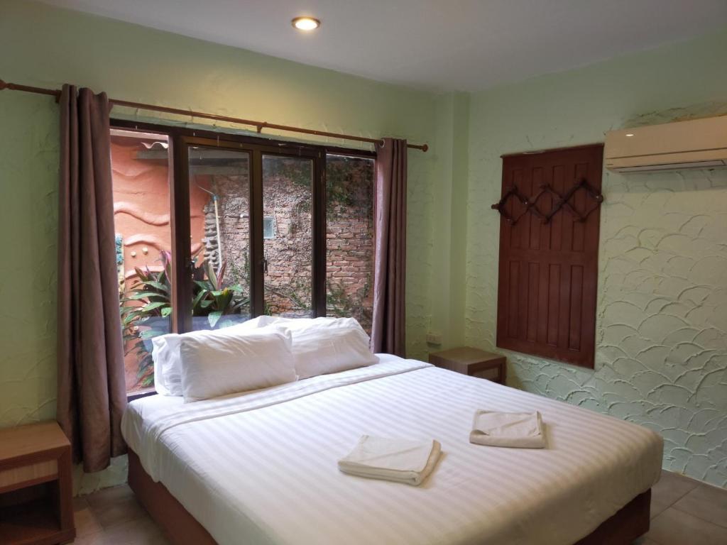 a bedroom with a large white bed with a window at Sea-Sun Bungalow & Resort in Ko Chang