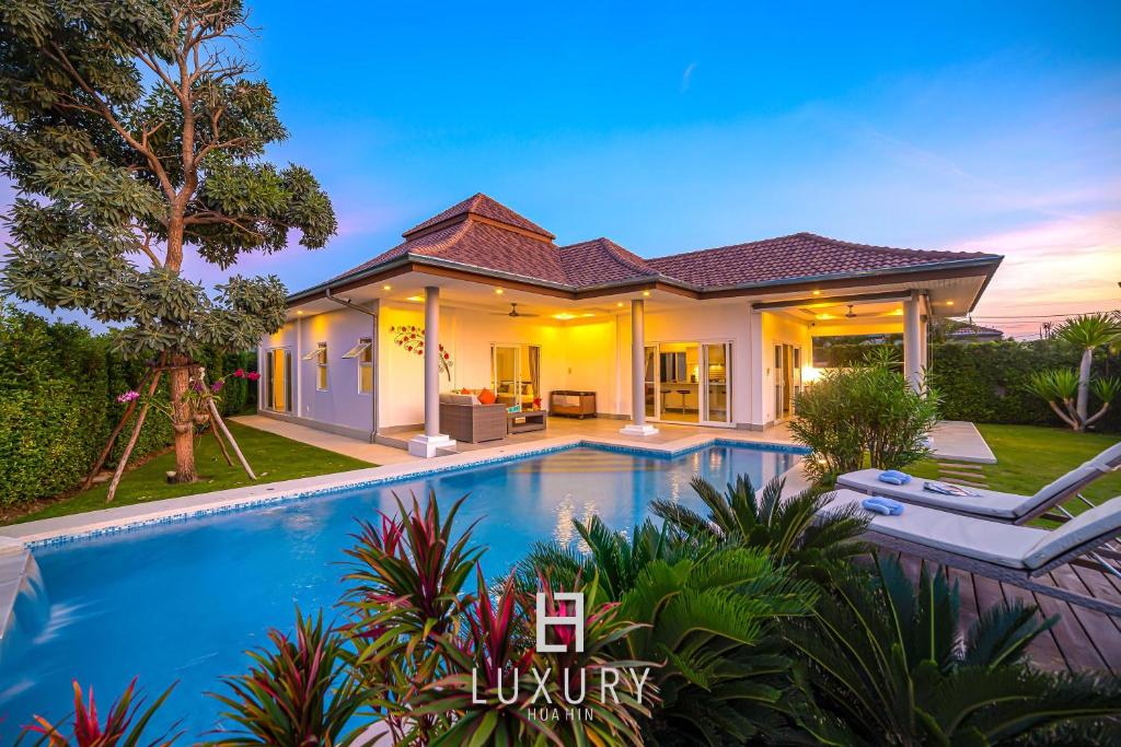 a villa with a swimming pool at dusk at Modern 3 Bedroom Pool Villa MP67 in Hua Hin