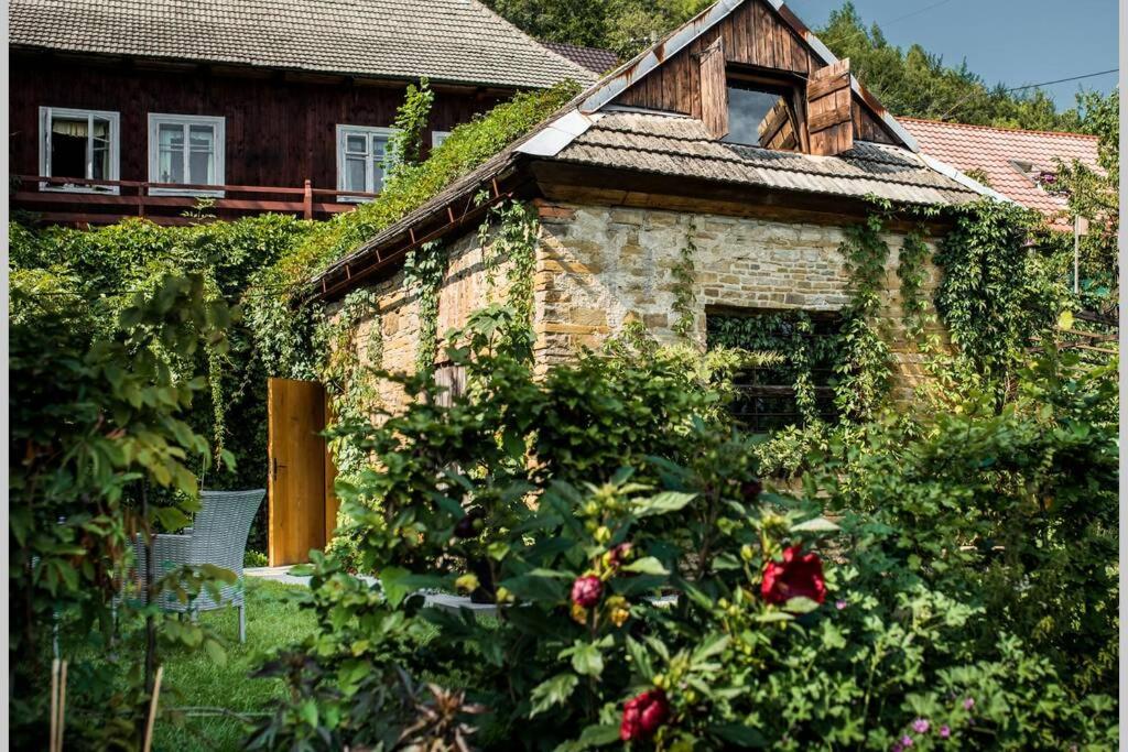 una casa de ladrillo con rosas delante en Mała Kuźnia, en Lanckorona