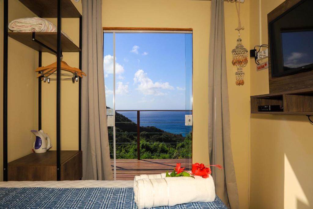 um quarto com uma cama e vista para o oceano em Flat Vista Mar Noronha em Fernando de Noronha