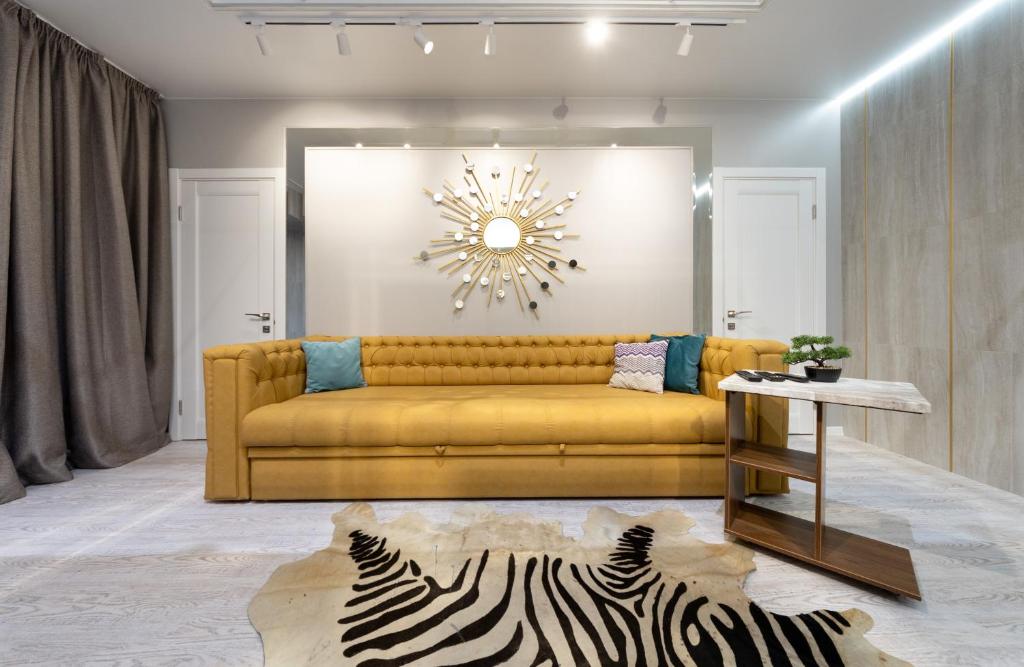 a living room with a yellow couch and a zebra rug at Pechersky Kvartal Apartments in Kyiv