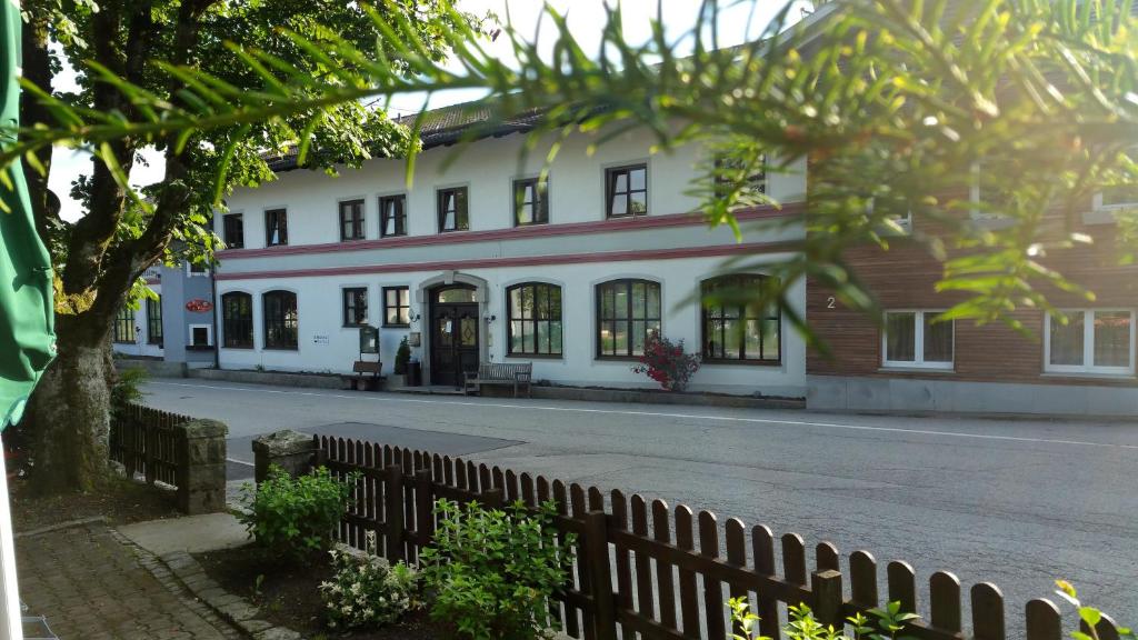 a white building with a fence in front of it at Edel Weiss Gästezimmer in Fürstenstein