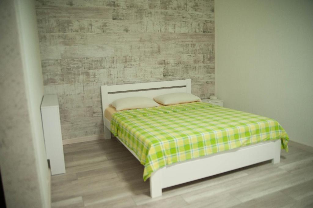 a small bedroom with a bed with a plaid blanket at Apartment FeLi House in Kyiv