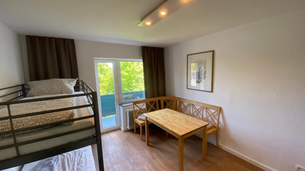 a bedroom with a table and a bunk bed at BS Living Apartment 1 in Braunschweig