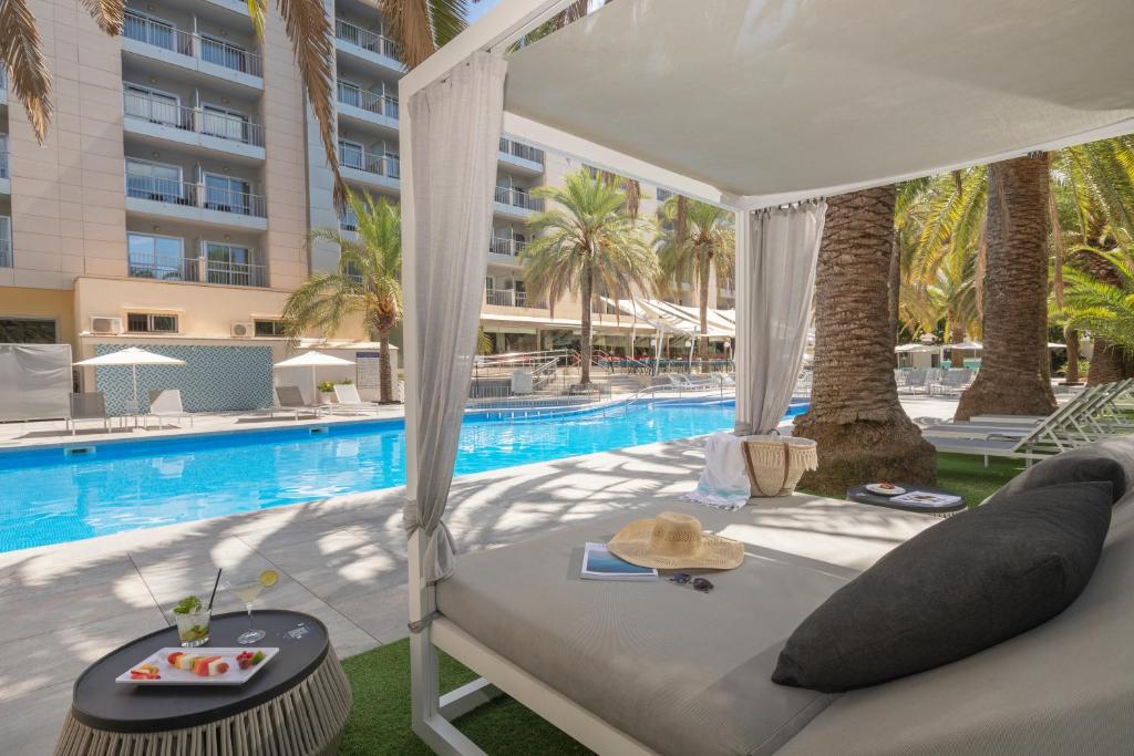 una cama frente a una piscina en Bordoy Cosmopolitan, en Playa de Palma
